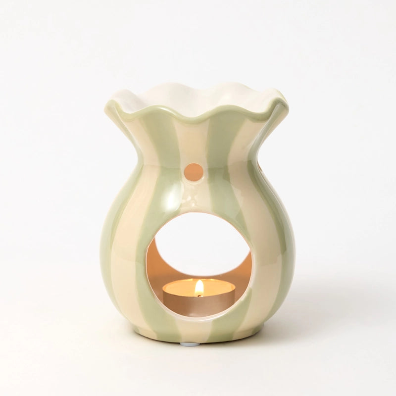 Light green ceramic wax melt burner with a small candle inside on a white background