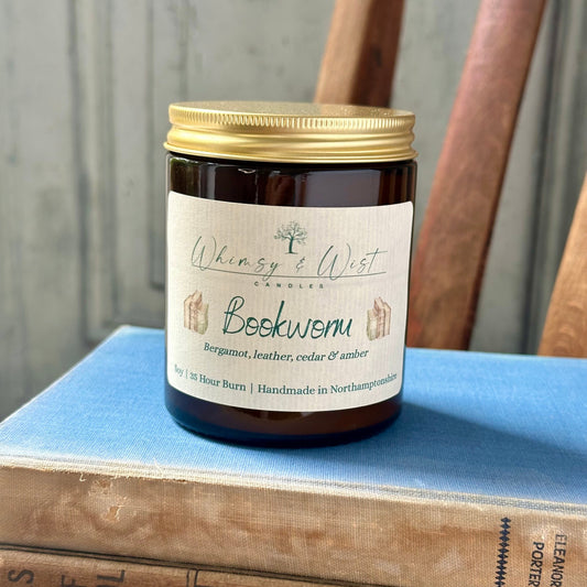 Bookworm soy candle in amber apothecary jar with gold lid, handmade in the UK.