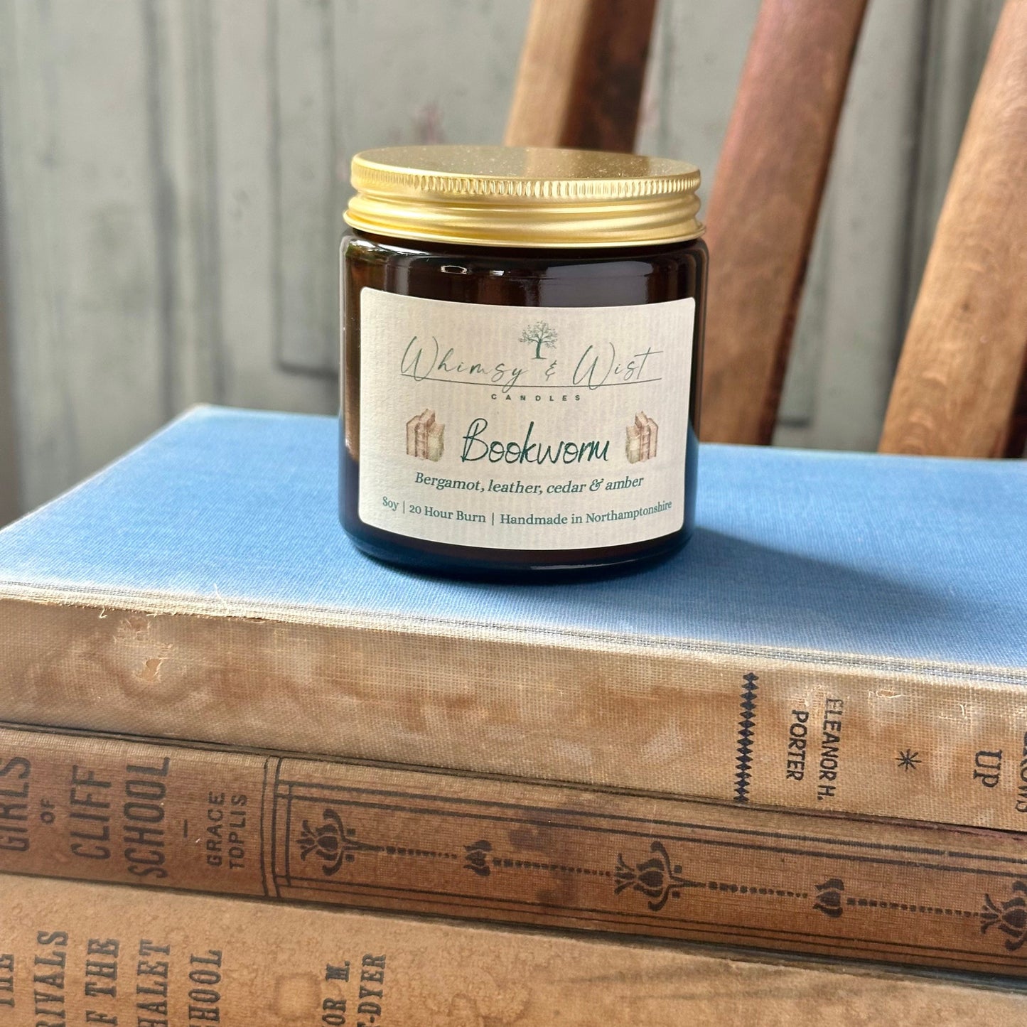 Bookworm soy candle in amber apothecary jar with gold lid, handmade in the UK.