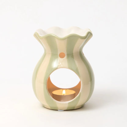 Light green ceramic wax melt burner with a small candle inside on a white background