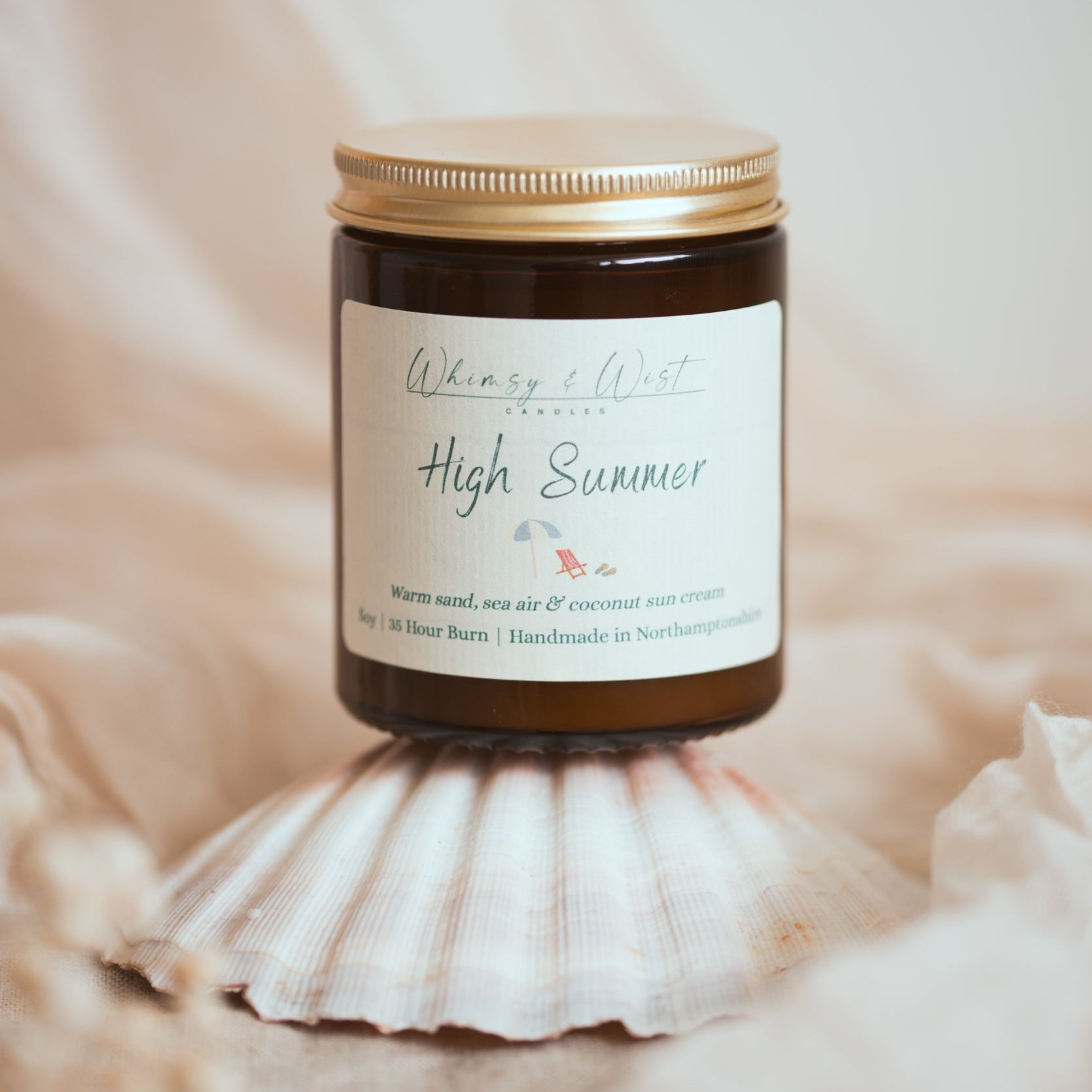 Summer scented candle balancing on a sea shell