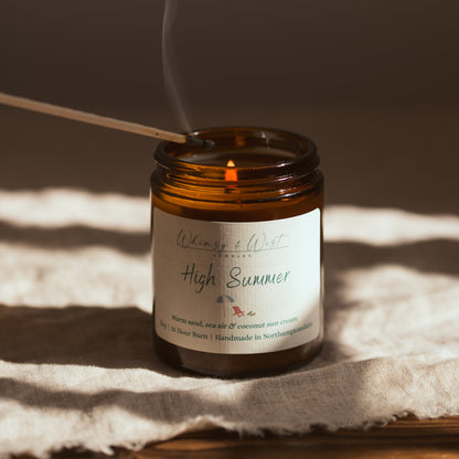 Summer scented candle being lit with a match