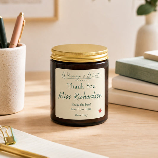Personalised candle labeled 'Thank You Miss Richardson' on a desk with stationery items.