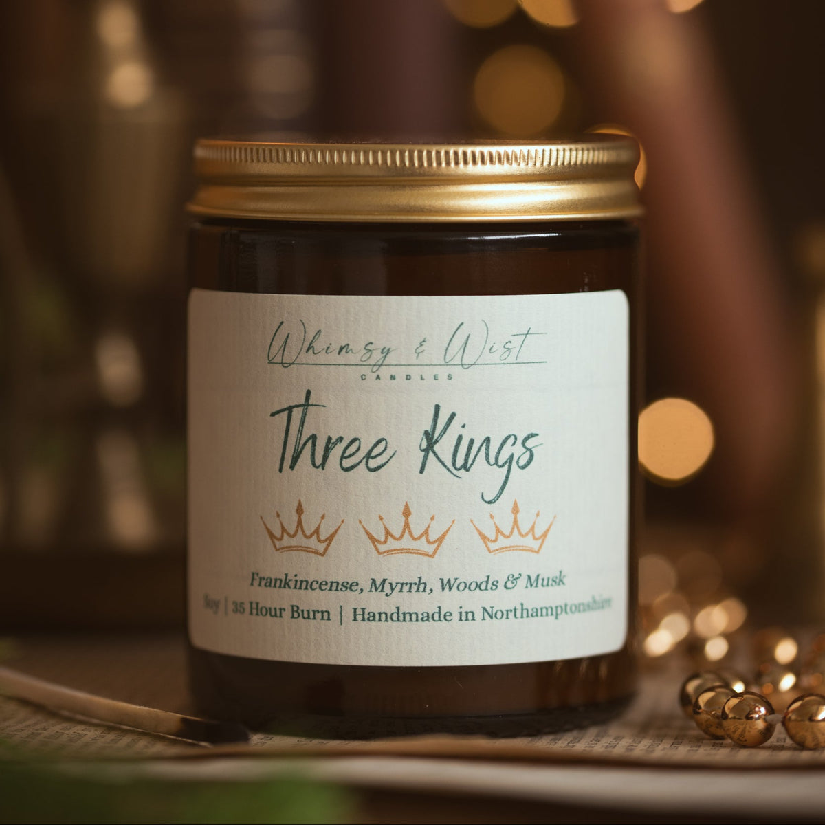 Whimsy & Wist Three Kings frankincense and myrrh soy candle with gold lid, with gold beads and old book pages